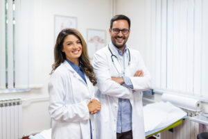 portrait-sourire-jeunes-medecins-debout-ensemble-portrait-personnel-medical-interieur-moderne-hopital-sourire-appareil-photo General Practitioner Consultation